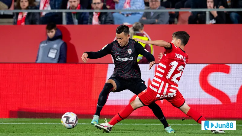 นักเตะของ Athletic Bilbao และ Girona กำลังแย่งบอลบนสนามหญ้า นักเตะของ Athletic Bilbao และ Girona กำลังแย่งบอลบนสนามหญ้า